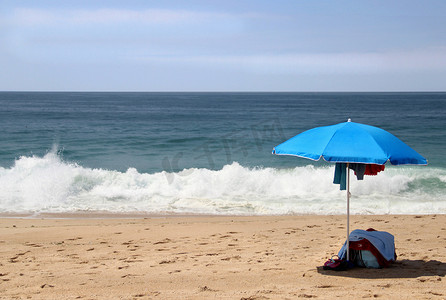空荡荡的海滩上的蓝色太阳伞
