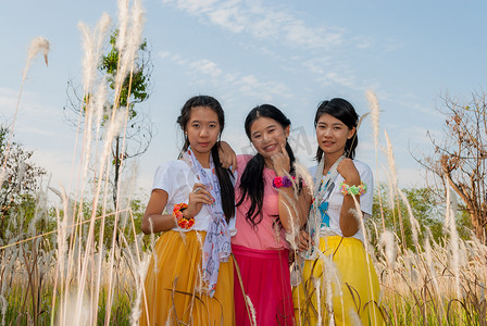 亚裔泰国女孩在田野里站在一起。