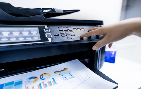 办公室工作人员在多功能激光打印机上打印纸张。