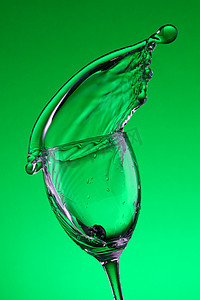 水流元素摄影照片_在玻璃杯中流动着新鲜的水流