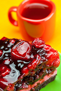盘子里放着浆果的漂亮蛋糕，桌上放着一杯茶