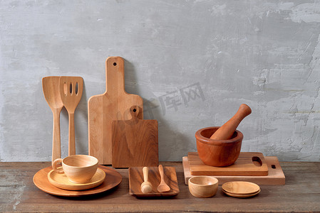 厨房工具，厨房架子上的橄榄切菜板靠在白砖墙上。