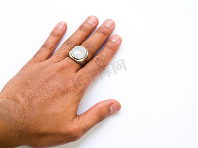 玉手摄影照片_一个男人的手，手指上戴着白色玉戒指，与白色隔离