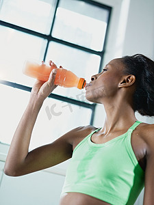 非洲妇女在健身房喝能量饮料