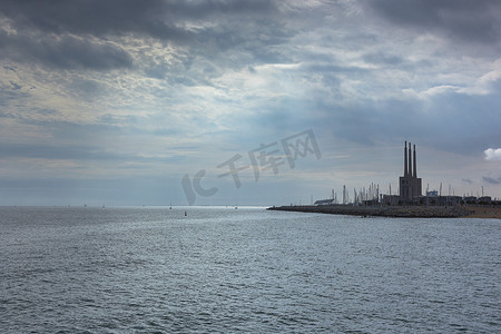 地中海的海景，可以看到一座废弃的旧热电厂发电