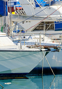 停泊在港口的游艇、游艇和摩托艇的特写，炎热的一天，码头的蓝水，蓝天