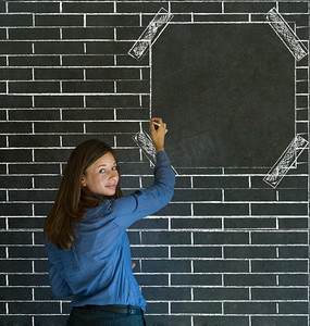 “砖墙告示板黑板背景的女商人、学生或者老师”