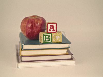 书籍上的苹果摄影照片_棕褐色风格儿童读物上的 ABC 积木和苹果