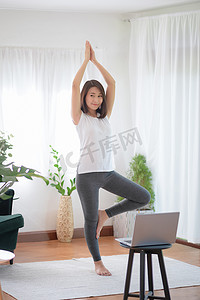运动潮流摄影照片_美丽的亚洲女性通过在家锻炼健康潮流生活方式来保持健康