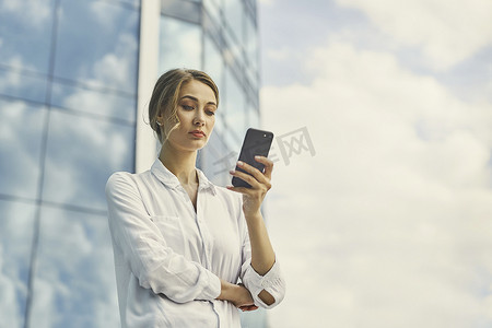 女商人成功的女人商务人士站在户外公司大楼外。