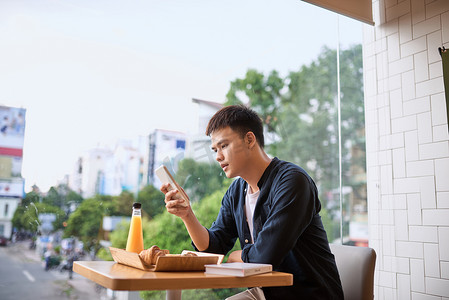 男人在下午茶时间使用手机，使用移动智能手机，使用无线通信的物联网生活方式和使用智能手机的互联网。