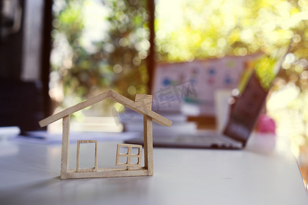 有背景的小木模型房子房地产经纪人代理人计算住房的价格。