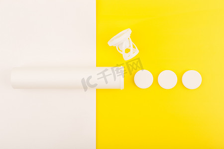 泡腾摄影照片_白色和黄色背景上带有泡腾维生素的开管的创意公寓