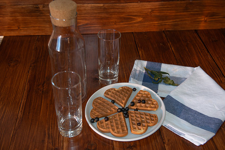 一个空瓶子、两个玻璃杯和盘子上的威化饼