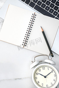 办公桌与空白笔记本、报告和大理石白色背景上的闹钟一起工作。