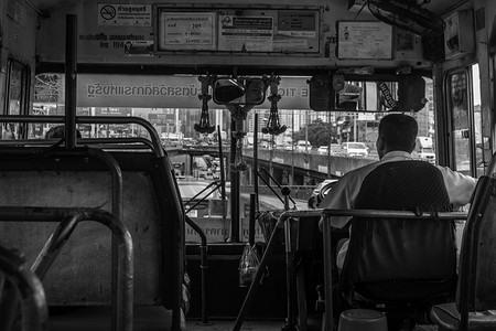 曼谷路上一辆旧巴士的巴士司机，黑白相间。