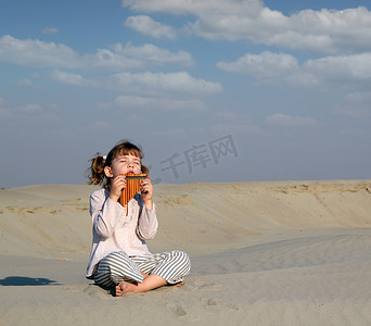 小女孩在沙漠中用排管演奏音乐