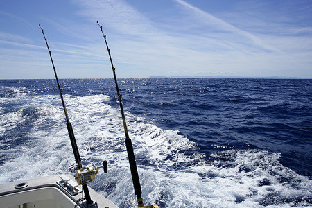 漂亮卷轴摄影照片_用拖钓竿和卷轴在船上钓鱼。