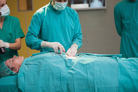 代运营摄影照片_外科医生打开病人的腹部