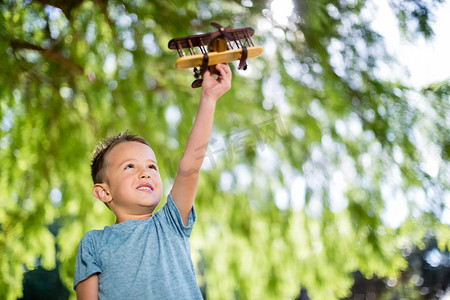男孩在公园里玩玩具飞机
