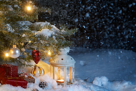 圣诞作文 — 圣诞树下雪地里的礼物和灯笼，装饰着灯光和圣诞树装饰，复制空间，文字位置