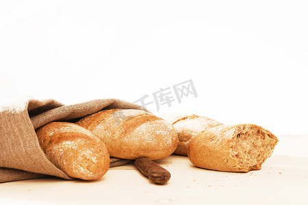 黑麦摄影照片_用亚麻织物和一把旧刀做的黑麦面包