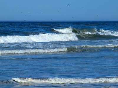 大海浪拍岸摄影照片_“晴朗的日子里，海浪拍岸”