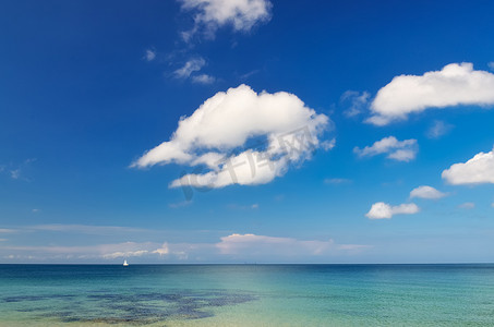 与蓝色多云天空和小风船的海洋风景