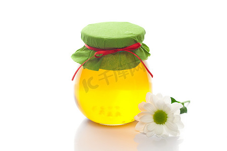 金色奶罐主图摄影照片_花和罐蜂蜜隔离在白色