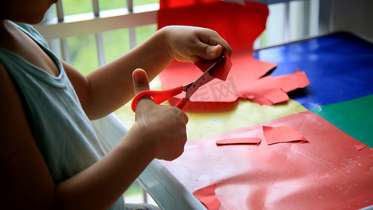 孩子用剪刀剪纸