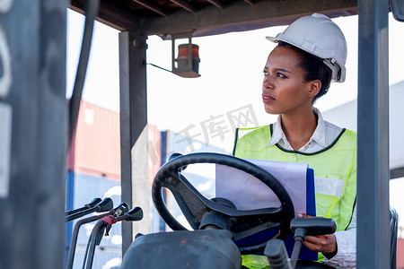 非洲裔美国女工头或货运集装箱工人坐在货车上，在工作期间向左侧看，也在思考行动。