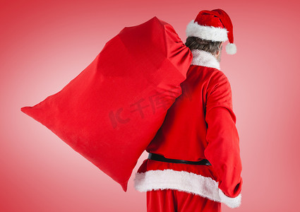 红色喜庆活动背景摄影照片_拿着礼品袋的圣诞老人站在红色背景下