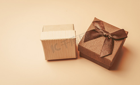 两个复古米色盒子，在米色孤立的背景上带有蝴蝶结。