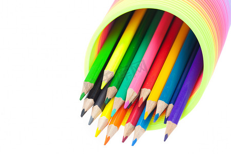 五颜六色的玩具弹簧和彩色铅笔隔离在白色