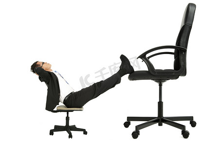 升职考核摄影照片_商人坐在大椅子上的小椅腿上考虑升职