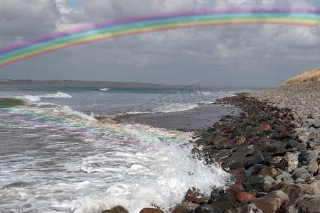 鹅卵石上滚动的波浪与彩虹