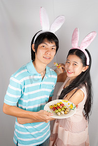 亚洲兔子爱好者拿着被刺穿的复活节彩蛋。