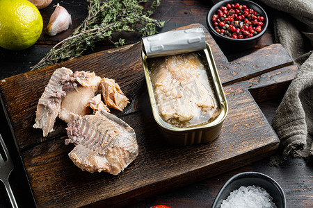 罐装野生阿拉斯加鲑鱼，在木制切菜板上，在旧的深色木桌背景上。