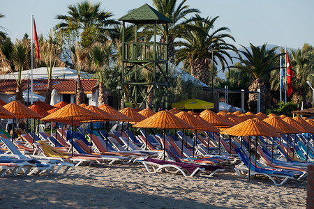 沙滩躺椅遮阳伞摄影照片_海边的沙滩躺椅和遮阳伞。