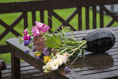 雨淋摄影照片_雨淋在花瓶上，花瓶上有一束五颜六色的鲜花