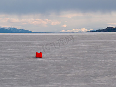 “红色塑料桶迷失在结冰的拉贝格湖，育空地区”