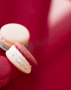 咖啡甜点摄影照片_酒红色背景的法式马卡龙、巴黎别致的咖啡甜点、甜食和豪华糖果品牌的蛋糕马卡龙、假日背景设计