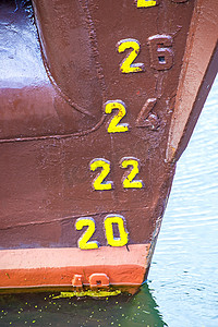 红色船锚摄影照片_一艘旧船的吃水标记