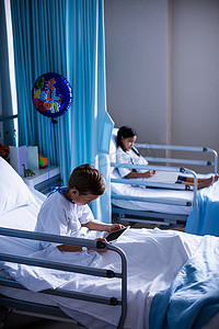 数字平板电脑和书坐在床上的病人