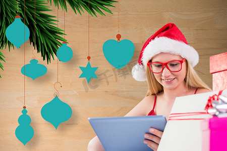 圣诞帽绿色摄影照片_戴着圣诞帽的漂亮女人使用数字平板电脑