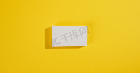 黄色背景上的一叠白色矩形名片、公司品牌、地址