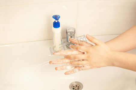 检疫期间，女孩在街后洗手间洗手。预防冠状病毒大流行，用温水和抗菌肥皂彻底洗手。世界流行病概念。