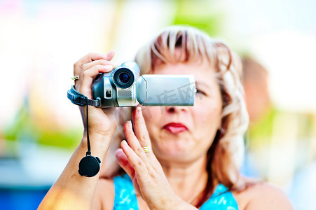 女人对迷你摄像机感兴趣地拍摄视频