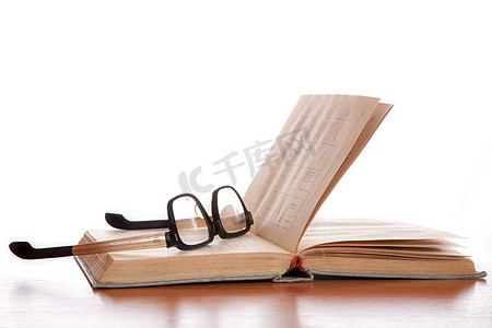 旧眼镜和放在桌子上的旧书