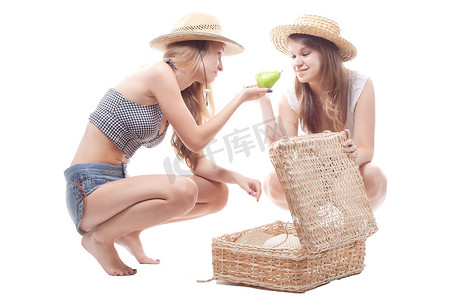 两个戴着草帽的女孩带着一个草编手提箱